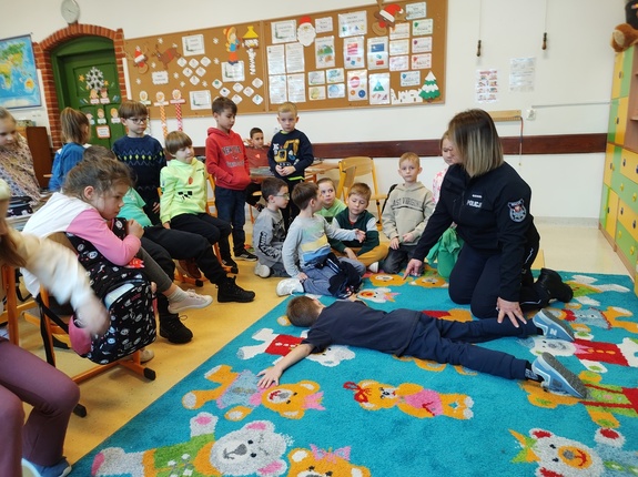 policjantka rozmawia z dziećmi w tle sala lekcyjna