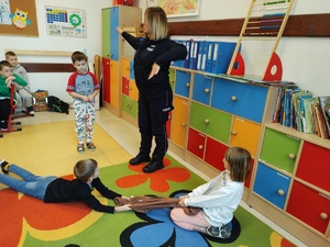 policjantka rozmawia z dziećmi w tle sala lekcyjna