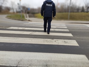 policjant przechodzący przez przejście w tle ulica i ruch pojazdów