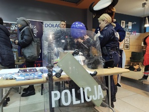 policjanci rozmawiają z odwiedzającymi WCK w tle inne osoby i hol