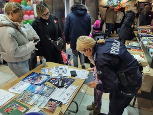 policjanci rozmawiają z odwiedzającymi WCK w tle inne osoby i hol
