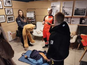 policjanci rozmawiają z odwiedzającymi WCK w tle inne osoby i hol
