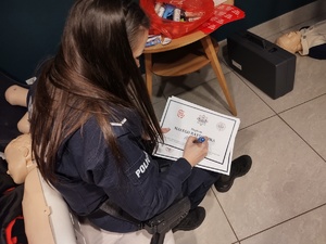 policjanci rozmawiają z odwiedzającymi WCK w tle inne osoby i hol