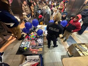 policjanci rozmawiają z odwiedzającymi WCK w tle inne osoby i hol