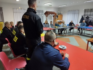 policjanci i strażacy rozmawiają z mieszkańcami w tle wyposażenie sali