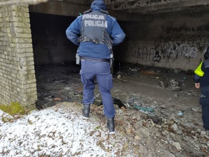 policjanci sprawdzają miejsca przebywania osób bezdomnych w tle pustostany i zarośla