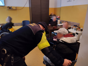 policjanci sprawdzają miejsca przebywania osób bezdomnych w tle pustostany i zarośla
