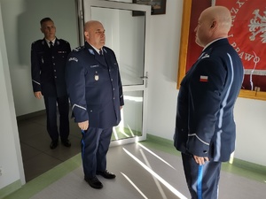 policjanci składają meldunek w tle wyposażenie sali