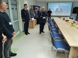 policjanci składają meldunek w tle wyposażenie sali