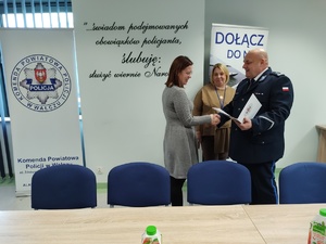 policjanci składają meldunek w tle wyposażenie sali