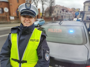 policjantka siedzi przy biurku w tle ściana