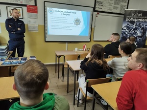 policjant rozmawia z uczniami w tle wyposażenie sali lekcyjnej