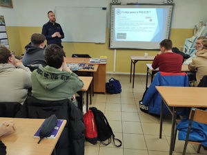 policjant rozmawia z uczniami w tle wyposażenie sali lekcyjnej