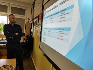 policjant rozmawia z uczniami w tle wyposażenie sali lekcyjnej