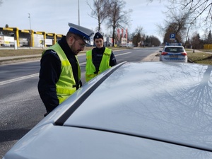 policjanci kontrolują pojazdy w tle ulica