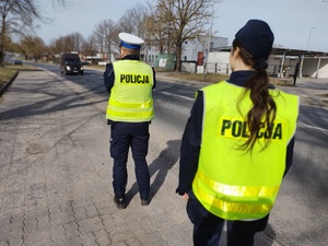 policjanci kontrolują pojazdy w tle ulica