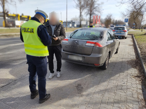 policjanci kontrolują pojazdy w tle ulica