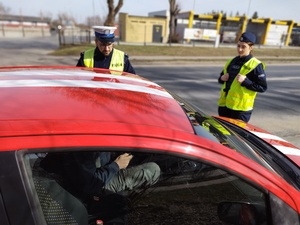 policjanci kontrolują pojazdy w tle ulica