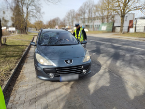policjanci kontrolują pojazdy w tle ulica