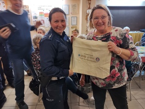 policjanci rozmawiają z seniorami w tle policjanci i seniorzy