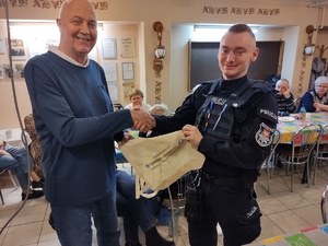 policjanci rozmawiają z seniorami w tle policjanci i seniorzy