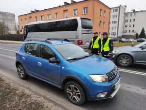 policjanci kontrolują pojazdy w tle ulica