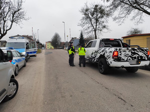 policjanci kontrolują pojazdy w tle ulica