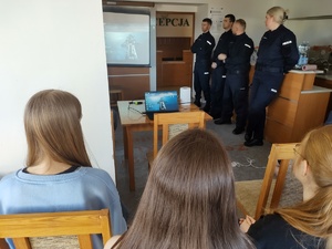 policjanci rozmawiają z licealistami w tle pomieszczenie świetlicy