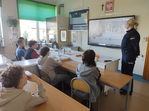 policjantka i uczniowie oglądają film w tle okna w sali