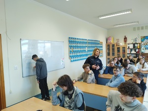 policjantka rozmawia z uczniami w tle sala lekcyjna