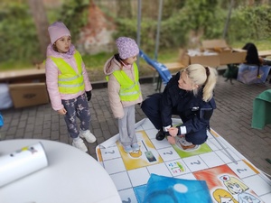 policjanci zabawiają dzieci zabawami edukacyjnymi w tle namiot policyjny i dzieci