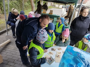 policjanci zabawiają dzieci zabawami edukacyjnymi w tle namiot policyjny i dzieci