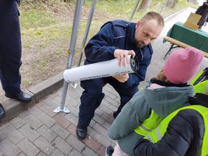 policjanci zabawiają dzieci zabawami edukacyjnymi w tle namiot policyjny i dzieci