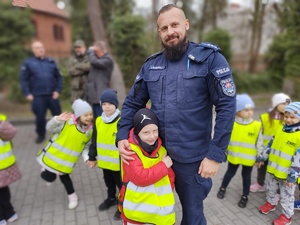 policjanci zabawiają dzieci zabawami edukacyjnymi w tle namiot policyjny i dzieci