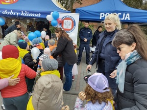 policjanci zabawiają dzieci zabawami edukacyjnymi w tle namiot policyjny i dzieci