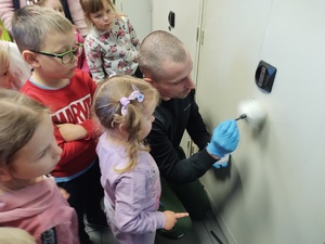 policjanci oprowadzają dzieci po terenie jednostki