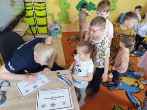 policjantki rozmawiają z dziećmi w tle wyposażenie sali i dzieci wraz z opiekunami