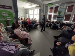 policjantka rozmawia z uczniami w te sala i uczniowie