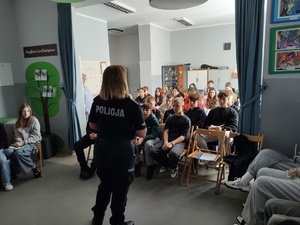 policjantka rozmawia z uczniami w te sala i uczniowie