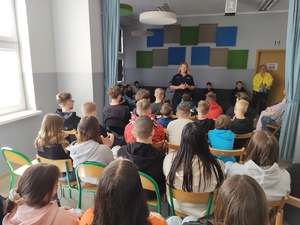 policjantka rozmawia z uczniami w te sala i uczniowie