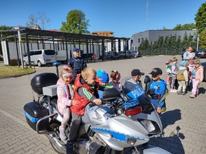 dzieci w towarzystwie policjantów zwiedzają komendę policji