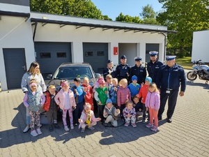 dzieci w towarzystwie policjantów zwiedzają komendę policji