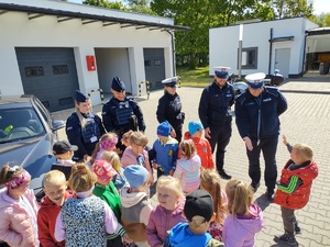 dzieci w towarzystwie policjantów zwiedzają komendę policji