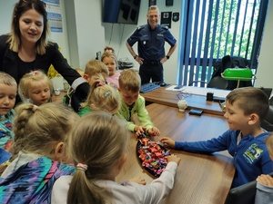 dzieci w towarzystwie policjantów zwiedzają komendę policji