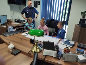 dzieci w towarzystwie policjantów zwiedzają komendę policji