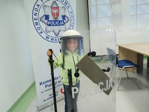 dzieci w towarzystwie policjantów zwiedzają komendę policji