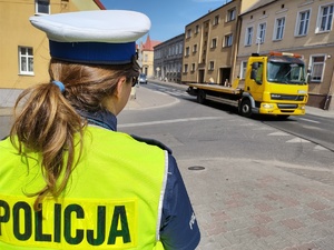 policjantka obserwuje ruch drogowy w tle ulica i pojazdy