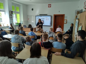 policjantka rozmawia z uczniami w tle tablica