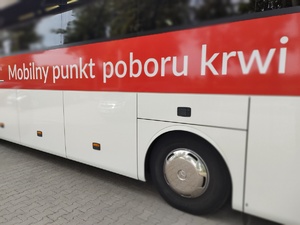 policjant oddaje honorowo krew w tle wyposażenie krwiobusa