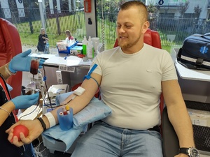 policjant oddaje krew w tle okno w ambulansie